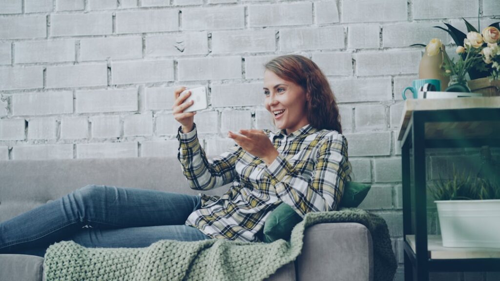 Woman relaxing at home while using smartphone for personal daily tasks and communication