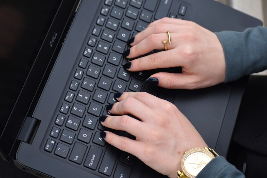 Businesswoman hands typing on laptop keyboard creating blog content