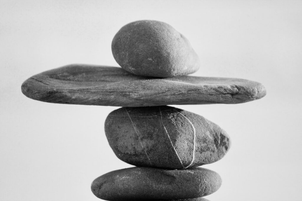 Balanced stacked rocks representing the pros and cons of free web hosting
