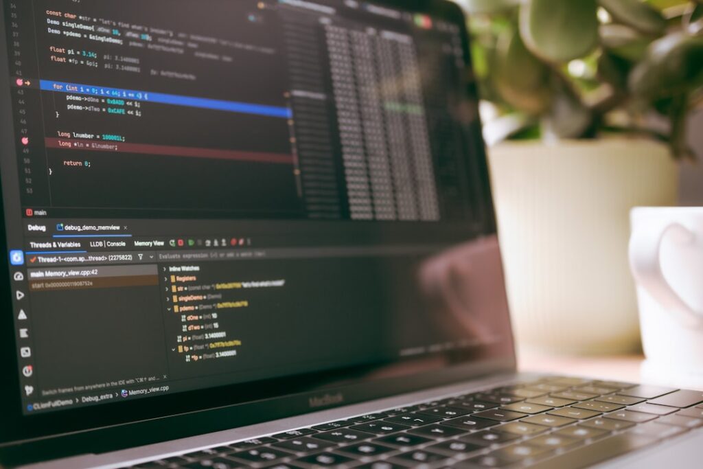 Developer workspace with laptop displaying programming code and syntax highlighting