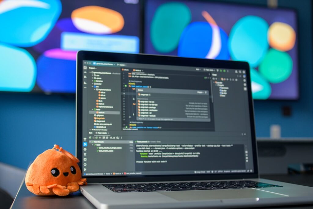 Developer laptop showing code editor with programming interface and GitHub Octocat mascot
