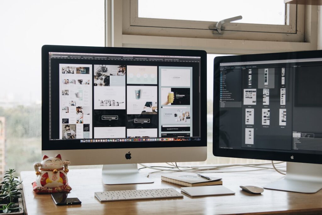 Clean workspace with dual monitors showing design tools and website layouts