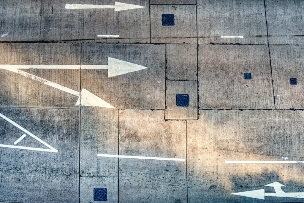 Aerial view of road arrows and directional markings representing decision pathways