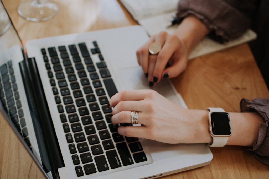 Solopreneur typing on a laptop, using AI writing tools to create blog content faster