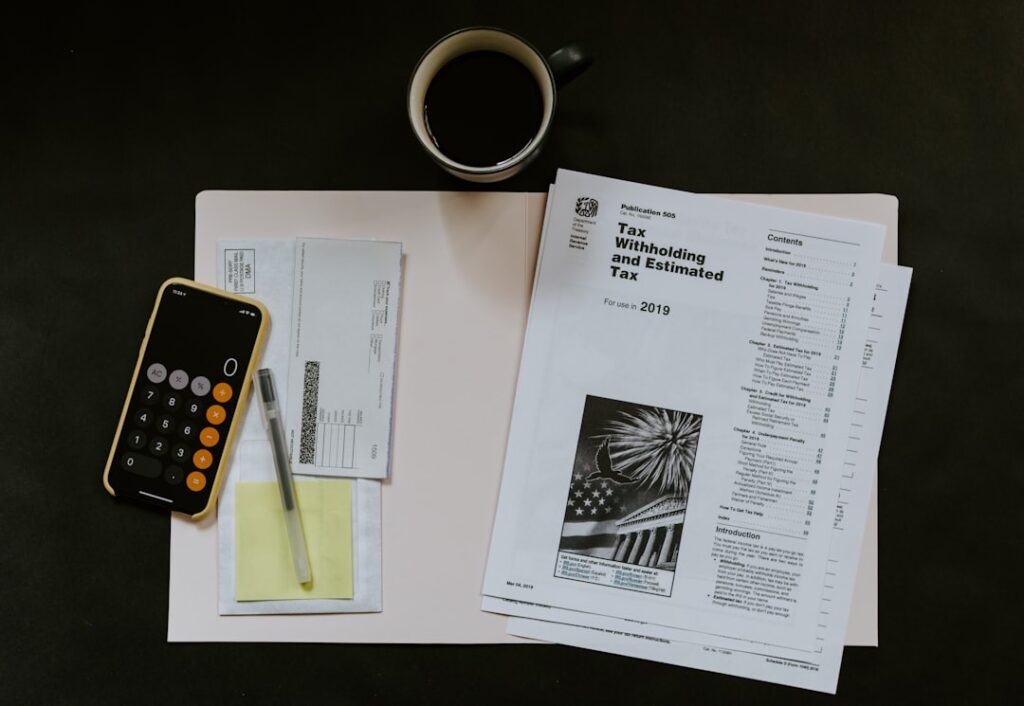 Calculator, documents and tax papers on a desk representing hidden renewal costs in domain hosting pricing