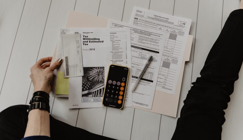 Person calculating hosting costs and analyzing financial documents with calculator