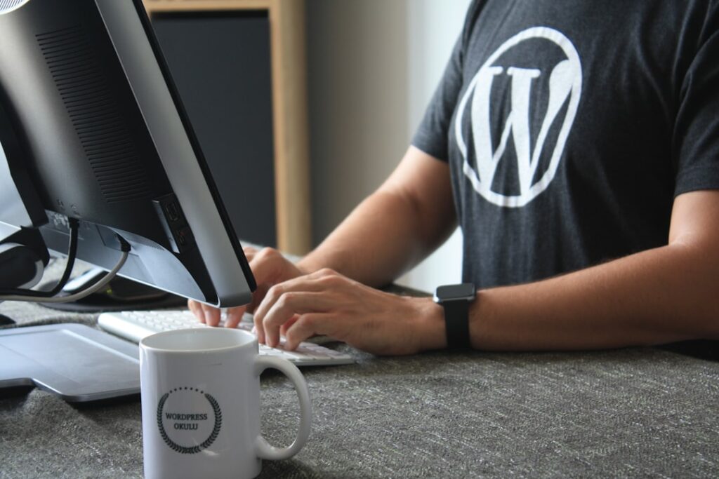 WordPress developer working at desktop computer wearing WordPress t-shirt — photo by Fikret tozak on Unsplash