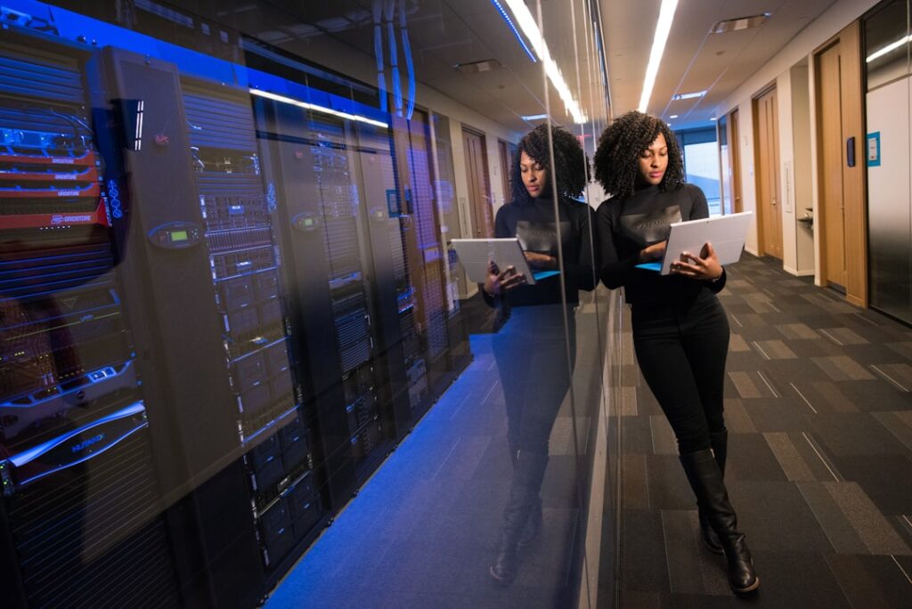Professional women working with server technology in a modern data center, representing website hosting decision-making for small businesses. Photo by ThisisEngineering RAEng on Unsplash
