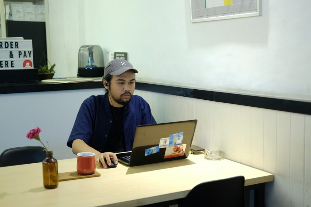 A solo content creator working on a laptop at a cafe, representing the small business owner and blogger audience for AI writing tools.
