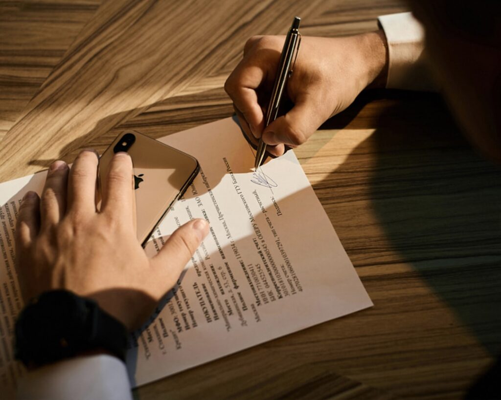 Person carefully reviewing a document before signing, representing the importance of reading the fine print on AI tool subscriptions and pricing terms