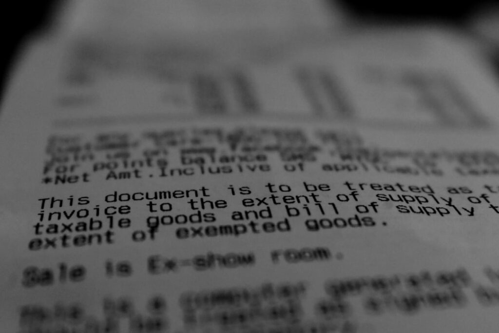 Close-up of fine print on an invoice document, representing hidden renewal costs and billing gotchas in web hosting