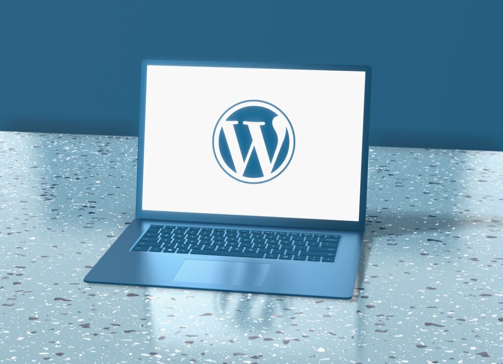 Laptop displaying the WordPress logo on a clean blue background, representing the WordPress content management system