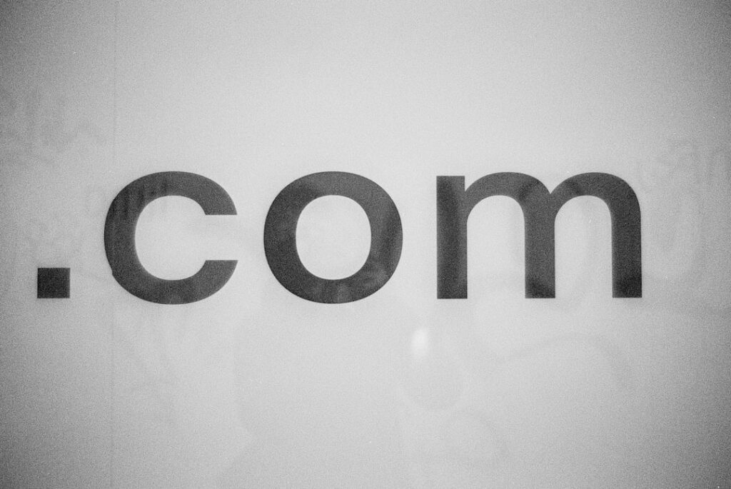 Close-up black and white .com domain name sign representing domain registration and web identity