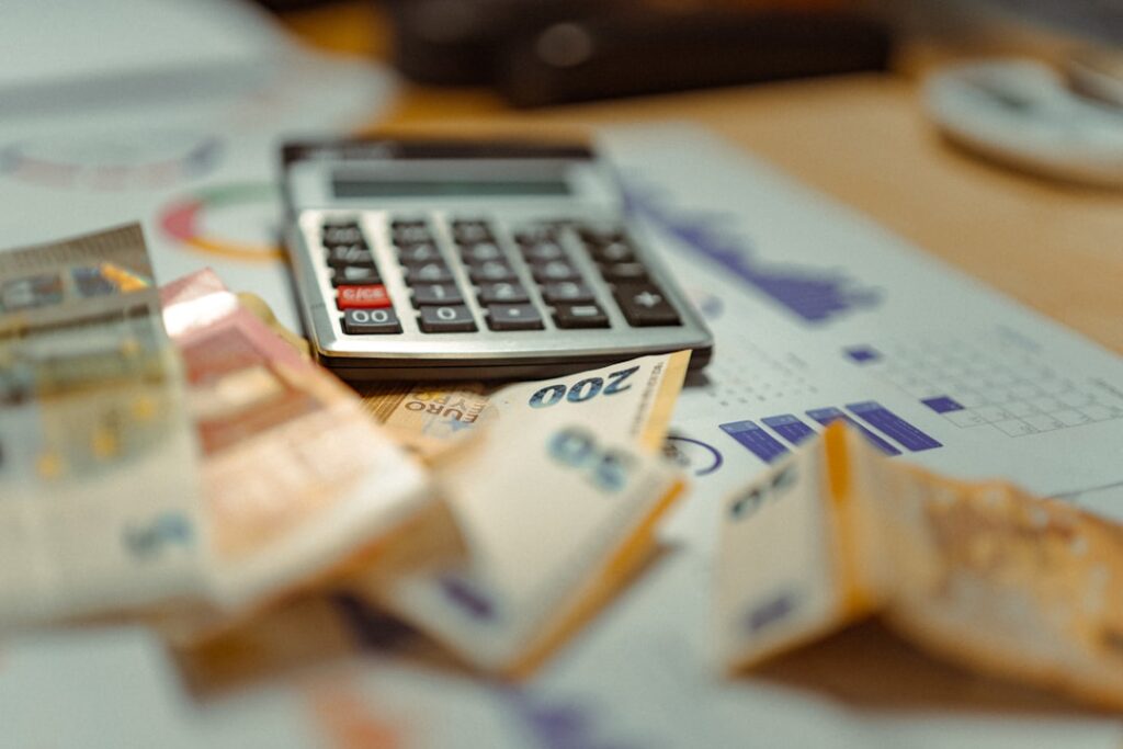 Calculator with euro banknotes and household budget receipts showing financial planning