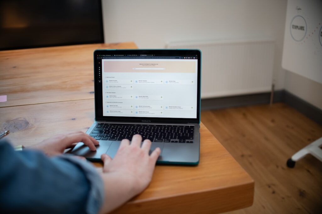 Person reviewing website hosting dashboard on a laptop at a wooden desk - best website domain host guide