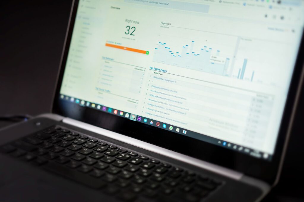 Laptop screen displaying a real-time website analytics dashboard with visitor data and traffic charts