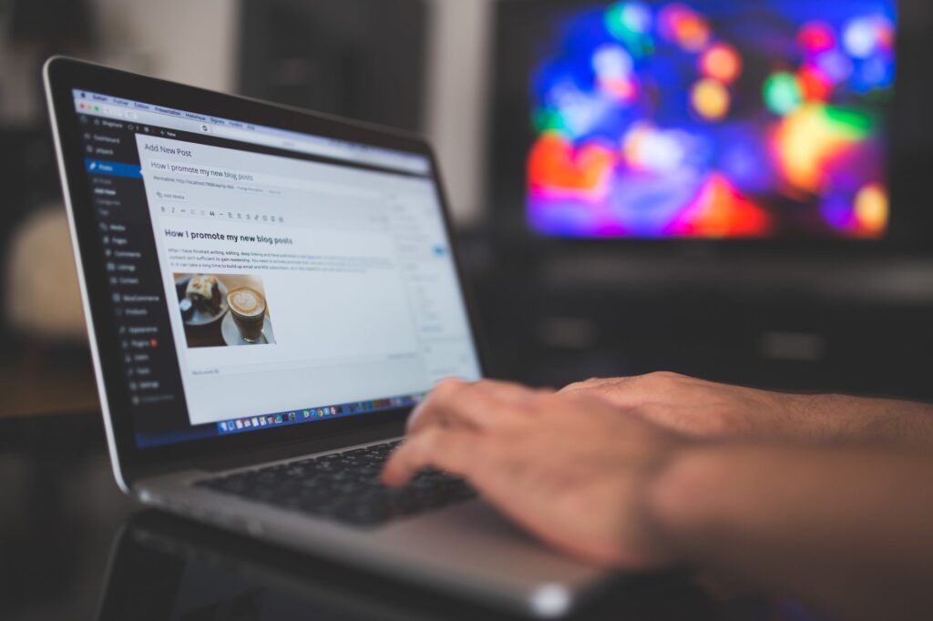 Hands typing on a laptop with a WordPress blog post visible on screen, illustrating how content creators use AI search tools in their research workflow