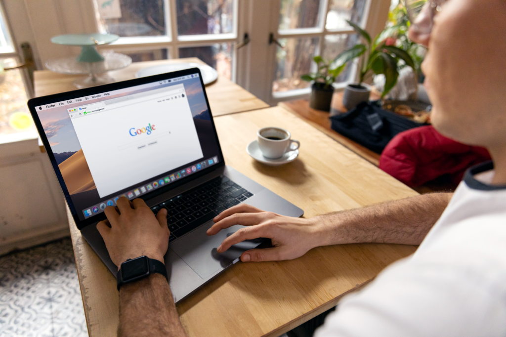 Person using a laptop to search Google in a bright indoor setting, representing the shift from traditional to AI search engines