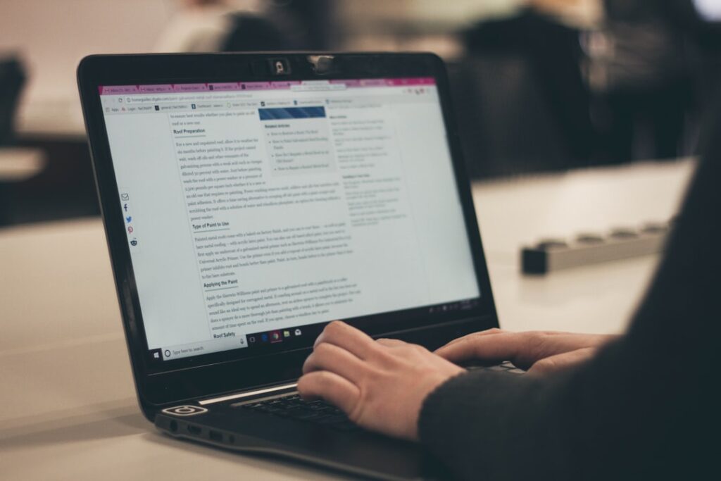 Person typing a blog article on a laptop, representing AI-assisted content creation and writing workflows.