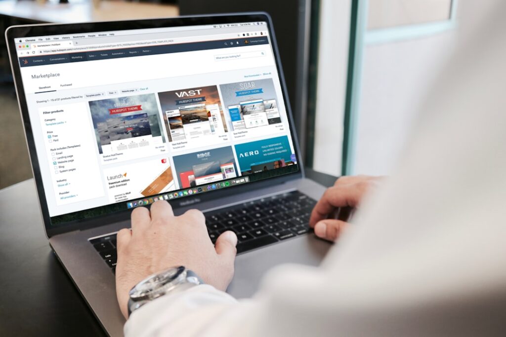 Person browsing website and hosting plan options on a MacBook laptop