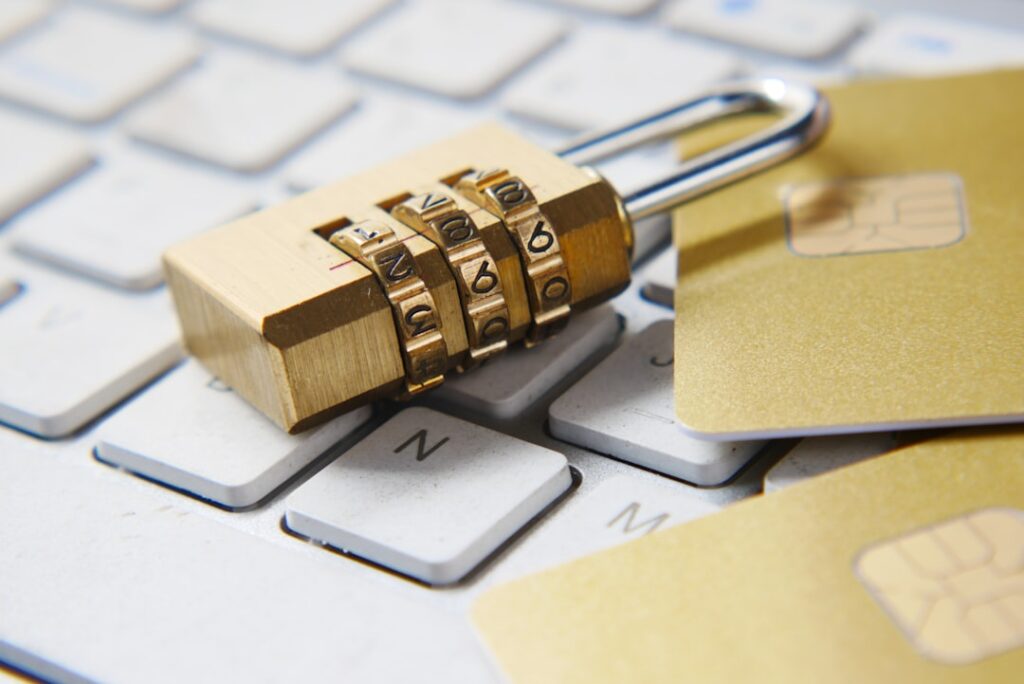 A padlock and credit cards resting on a computer keyboard, symbolizing data privacy and security risks to watch for in free AI tool free tiers
